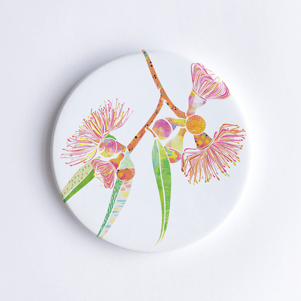 Round, hand printed ceramic coaster with illustration of pink, yellow, orange and green gum blossom flowers.