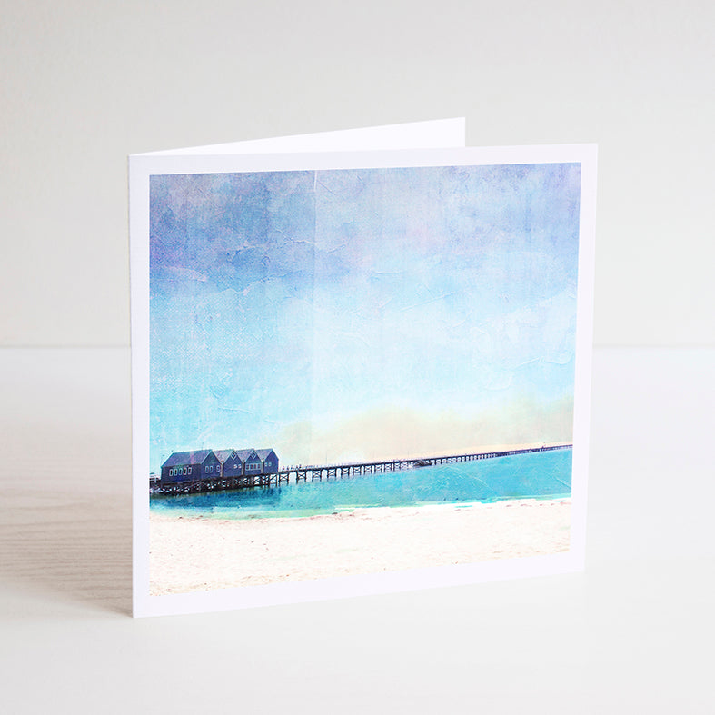 Square notecard with illustration of Busselton Jetty which consists of 4 boathouses on a 1.8km timber jetty over the ocean.