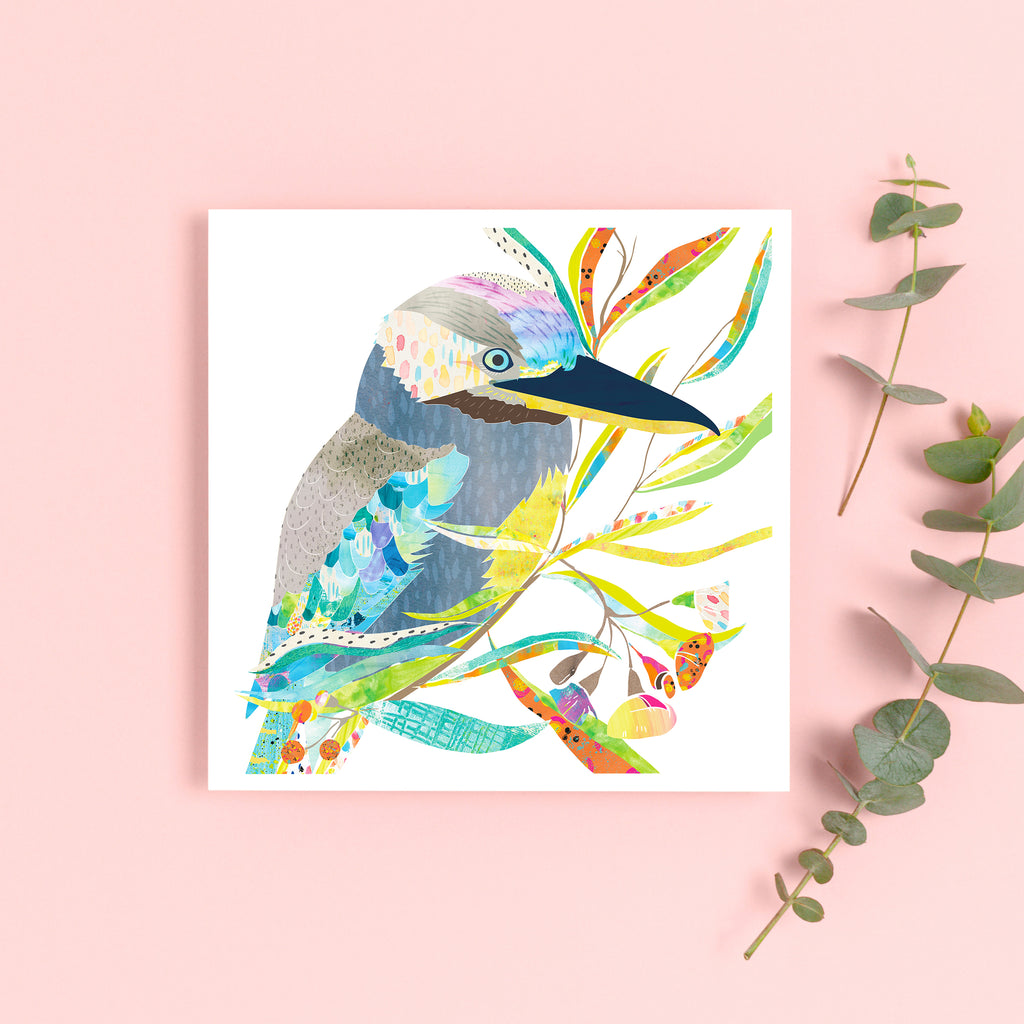 Illustration art print with a grey, blue-winged kookaburra bird on a branch with colourful leaves on pink background.