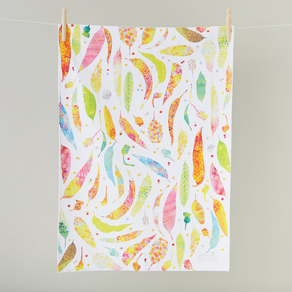 White tea towel with a bright, colourful gum leaves illustration. 