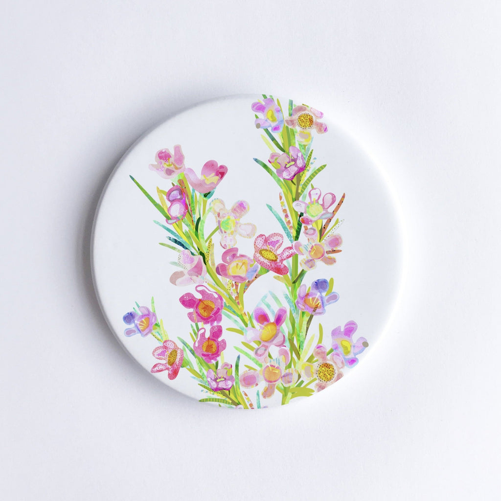       Round, hand printed ceramic coaster with illustration of pink, purple, yellow and green Geraldton wax flowers.