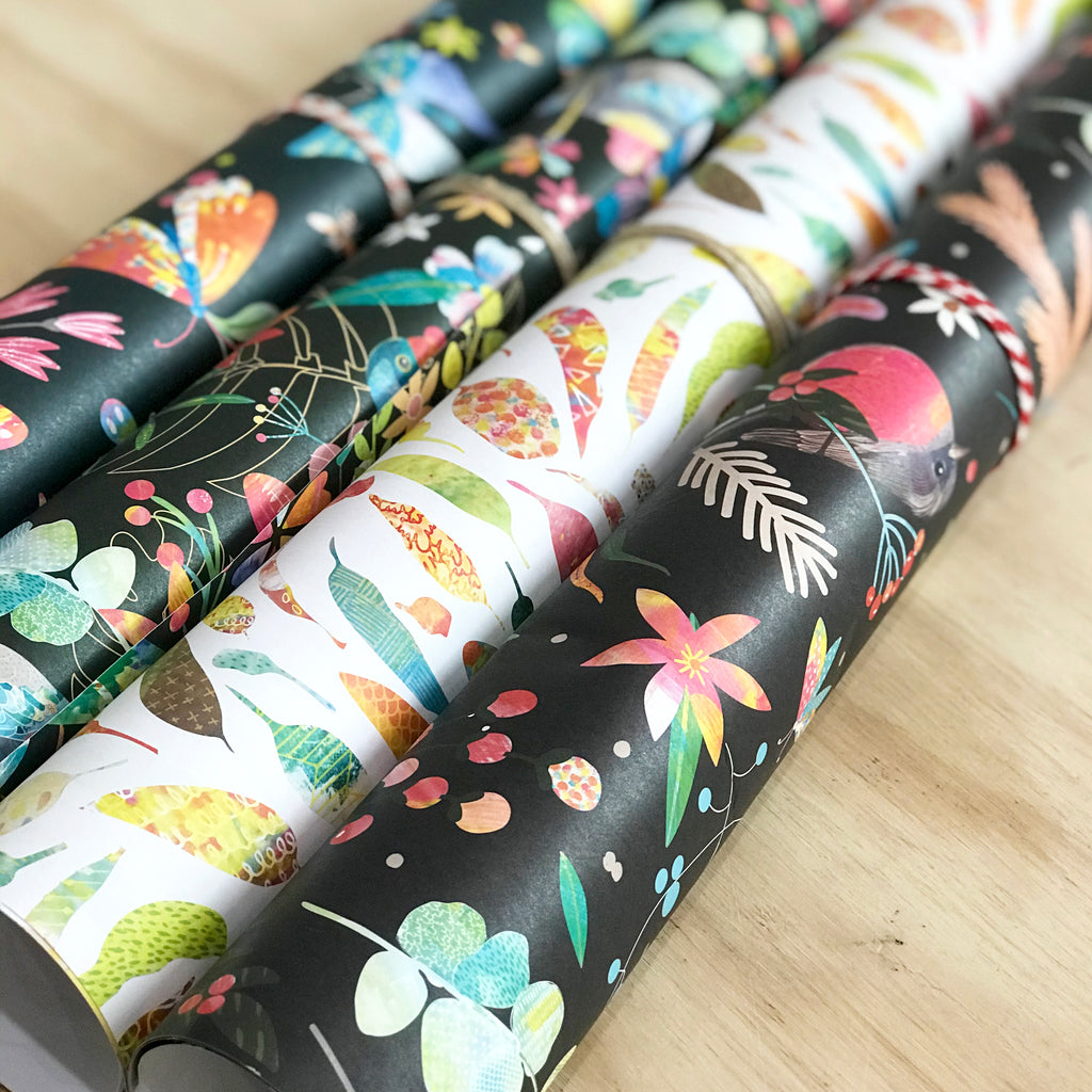  4 different gift wraps with illustration of colourful gum leaves on white background, australian bush birds on black background and colourful butterflies on black background.